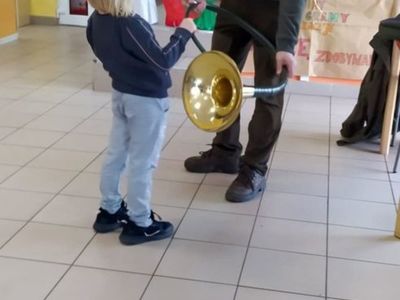 Słuchanie i próba gry na rogu dzieci z Placówki Wsparcia Dziennego w Laskach.