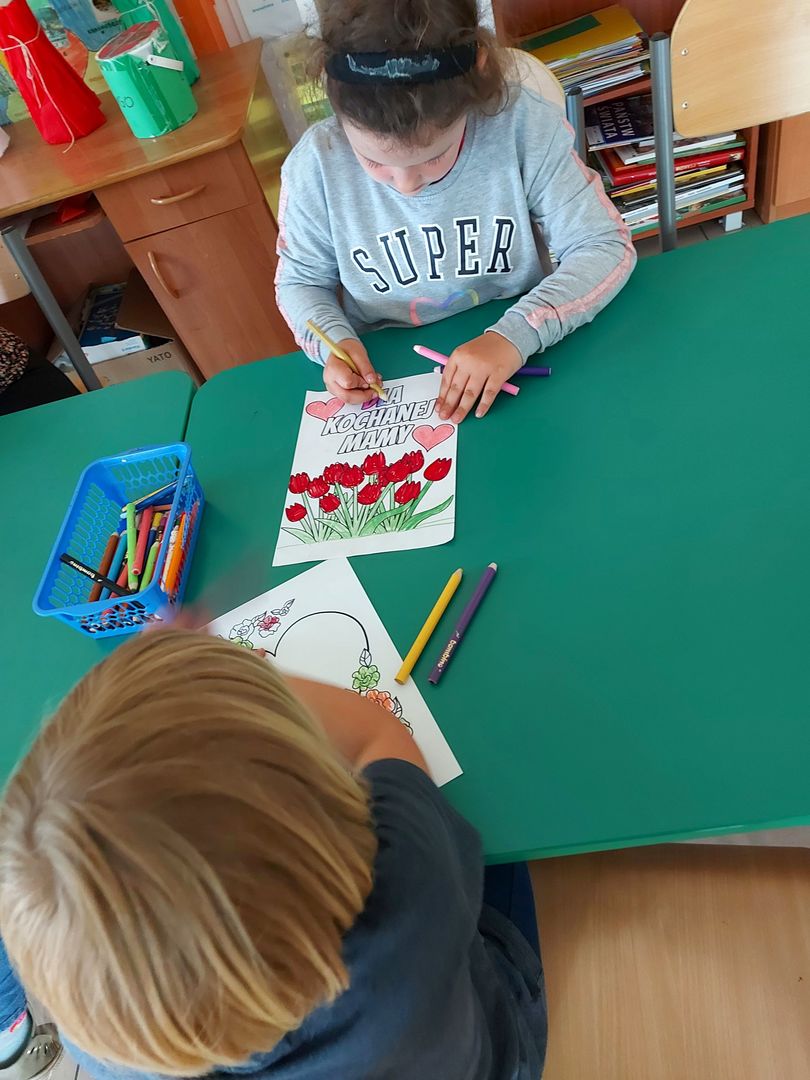 Podopieczne z Placówki Wsparcia Dziennego w Laskach w trakcie kolorowania laurek dla swoich mam.