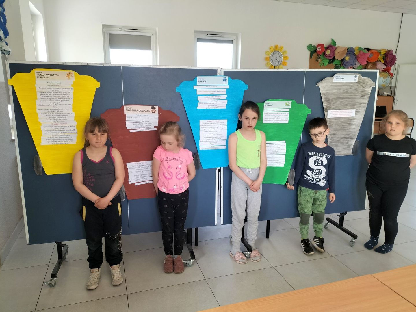 Dziewczynki z Placówki Wsparcia Dziennego w Kusicach przy tablicach z informacjami na temat realizowanego projektu. 