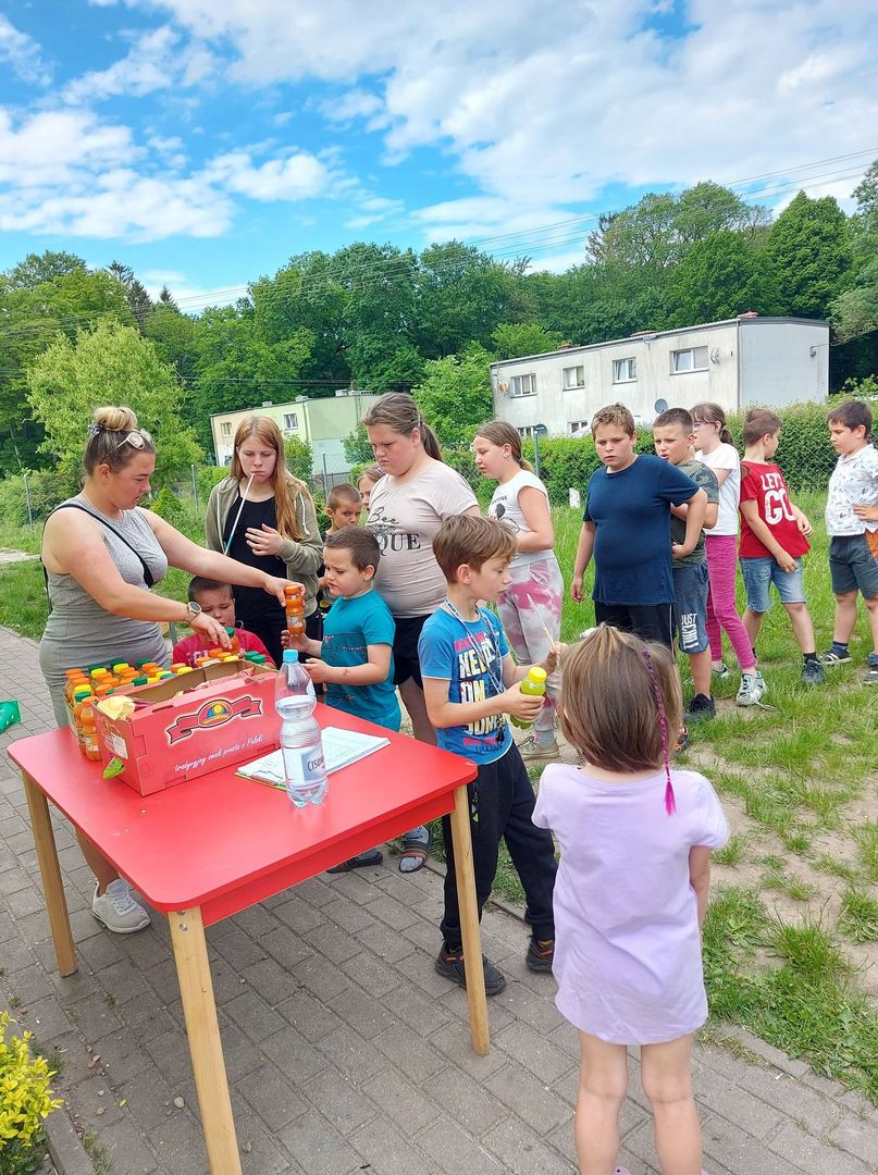 Dzieci z Placówki Wsparcia Dziennego z Lasek odbierają soczki.