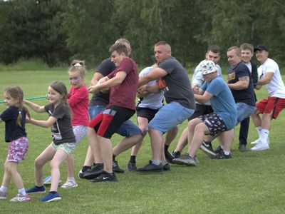 Uczestnicy pikniku integracyjnego w Zielnicy przeciągają linę.