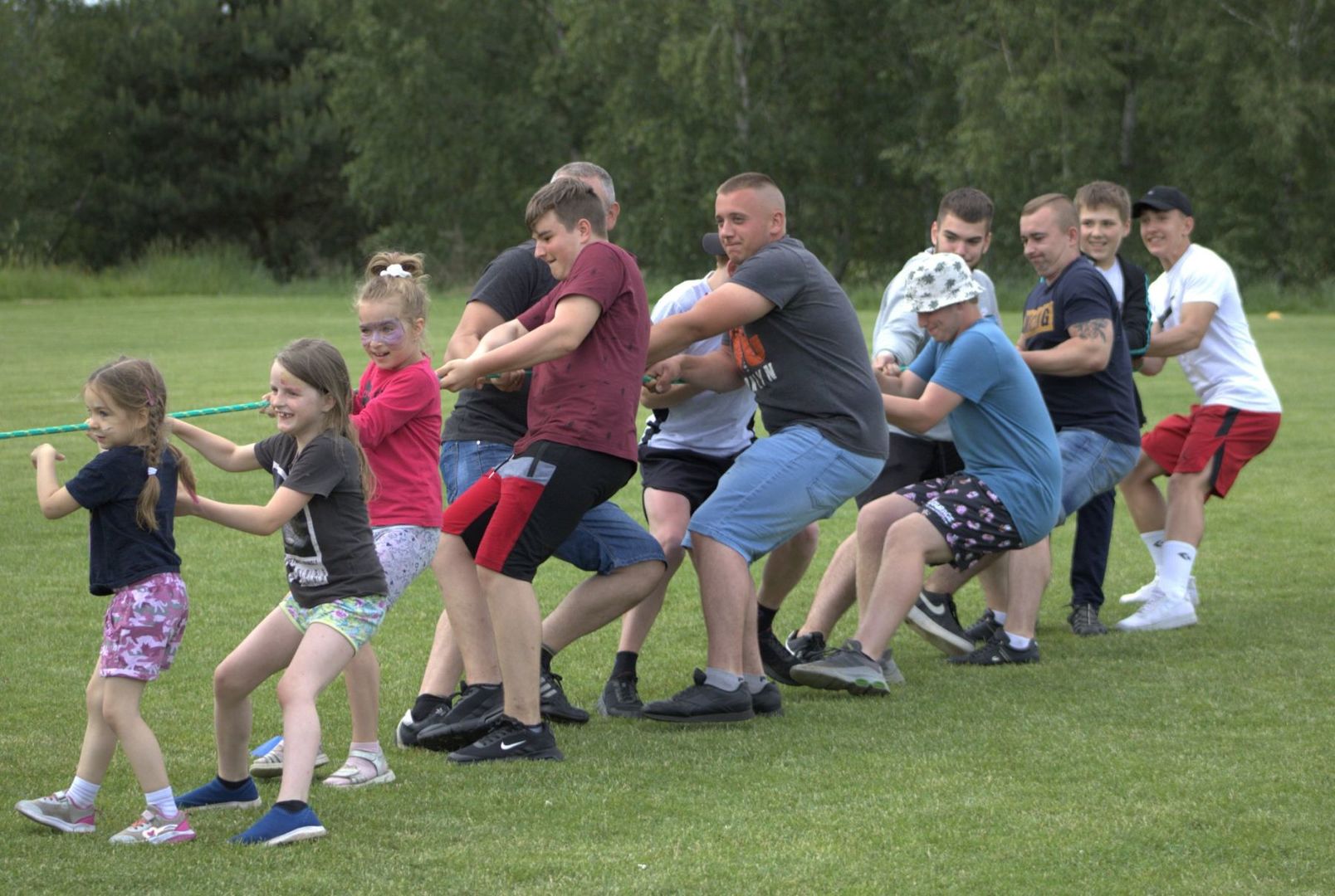 Uczestnicy pikniku integracyjnego w Zielnicy przeciągają linę.