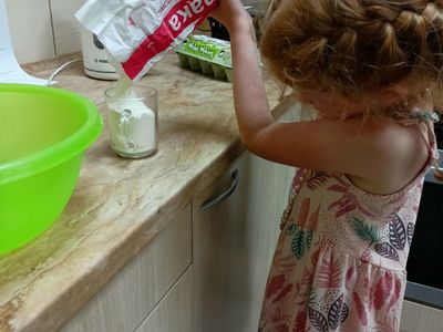Dziewczynka z Placówki Wsparcia Dziennego w Pękaninie przygotowuje ciasto na babeczki.