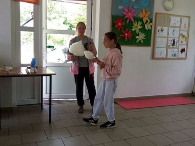 Dwie dziewczynki zajadają się watą cukrową. 