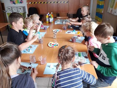 Dzieci malujące farbami plakatowymi figurki z masy solnej.