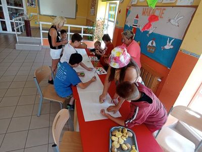 Wychowankowie z Placówki Wsparcia Dziennego z Lasek malują obraz farbami oraz wykonanymi pieczątkami z ziemniaków.