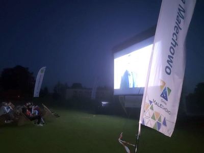 Nadmuchiwany ekran, winder Gminy Malechowo i widzowie oglądający film. 