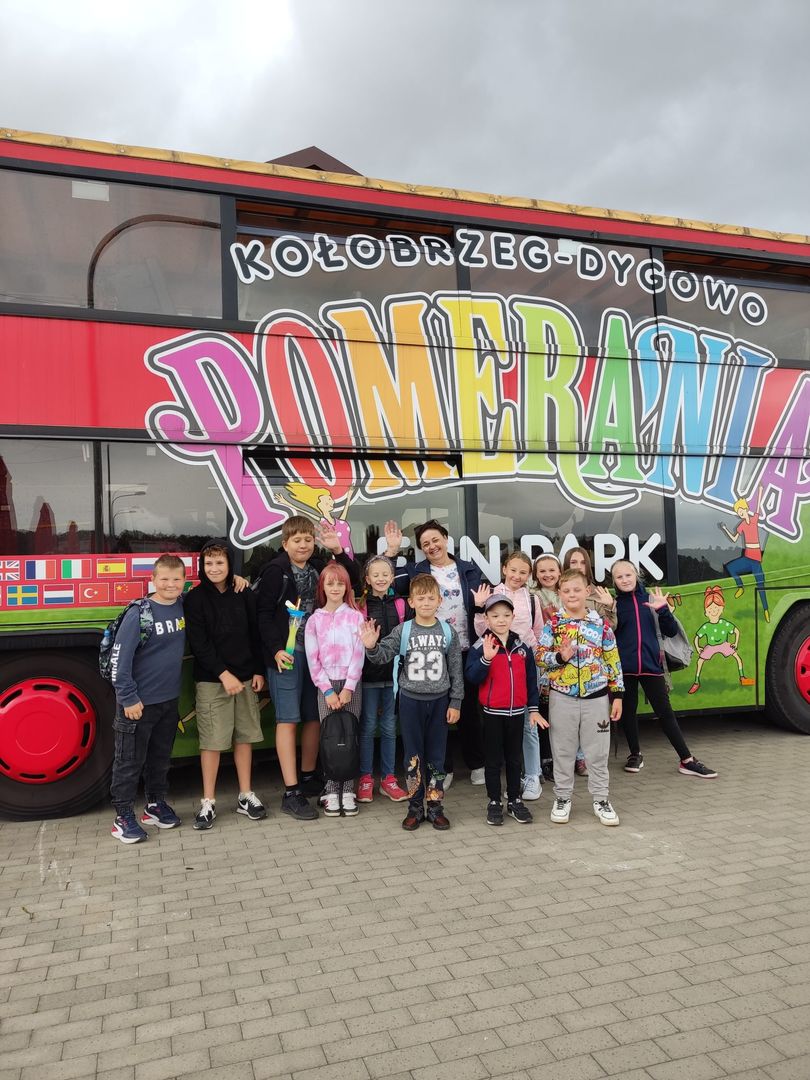 Dzieci z Placówki Wsparcia Dziennego wraz z opiekunem przed autobusem Pomerania.