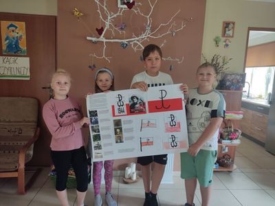 Dzieci z Placówki Wsparcia Dziennego pozują z wykonanymi plakatem z okazji rocznicy Powstania Warszawskiego.