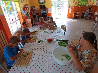 Dzieci z PWD Laski kroją warzywa i owoce na sałatkę. 