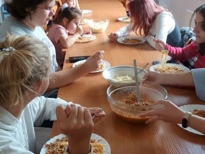 Dzieci spożywające spaghetti.
