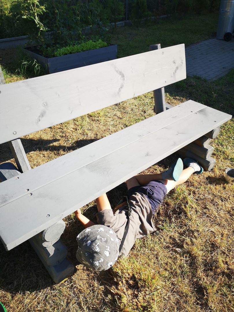 Chłopczyk z Placówki Wsparcia Dziennego w Kusicach podczas malowania ławek. 