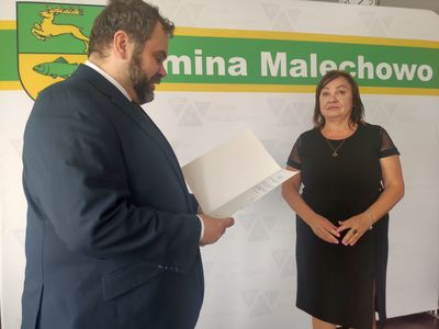 Wójt Radosław Nowakowski odczytuje treść zarządzenia, obok dyrektor Iwona Nowak - Gancarz.