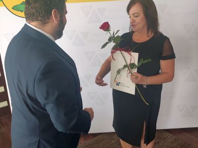 Wójt Radosław Nowakowski przekazuje różę i gratulacje dyrektor Iwonie Nowak - Gancarz.