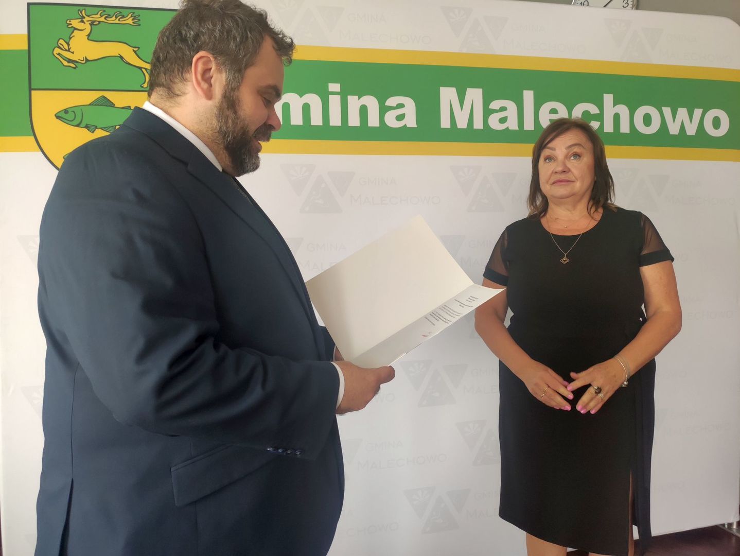 Wójt Radosław Nowakowski odczytuje treść zarządzenia, obok dyrektor Iwona Nowak - Gancarz.