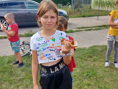Dzieci z Placówki Wsparcia Dziennego w Laskach jedzą kiełbaski. 