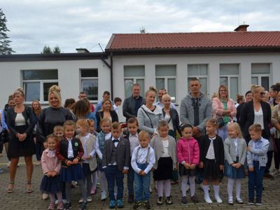 Dzieci z oddziału przedszkolnego wraz z wychowawcą i rodzicami w trakcie apelu szkolnego.