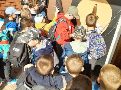 Dzieci z Zespołu Szkolno-Przedszkolnego w Malechowie rozczesują ogony koni, pozostałe obserwują je. 