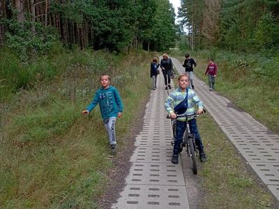 Wychowankowie z Placówki Wsparcia Dziennego w Laskach podczas spaceru do lasu.
