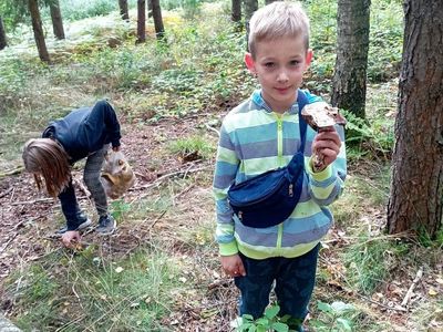 Wychowankowie z Placówki Wsparcia Dziennego w Laskach prezentują zebrane dary jesieni.
