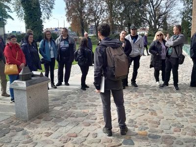Grupa podróżników z Sulechówka wsłuchana w opowieść przewodnika.