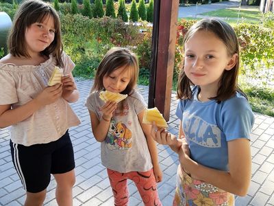 Dzieci w Przystaw spożywają przygotowane jedzenie.