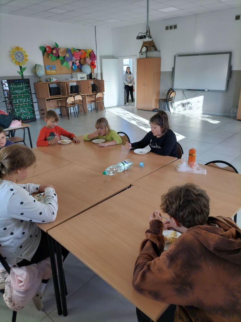 Dzieci z Placówki Wsparcia Dziennego w Kusicach zajadają się szarlotką. 