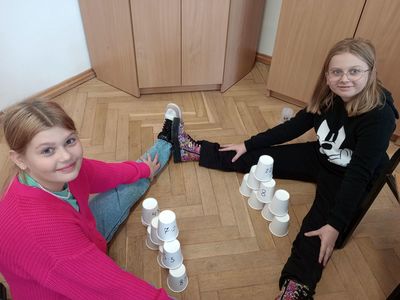 Dwie dziewczynki ze Szkoły Podstawowej w Lejkowie budują wieżę z kubków.