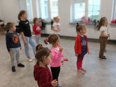 Dzieci z grupy początkującej z trenerem wykonują określone ćwiczenia. 