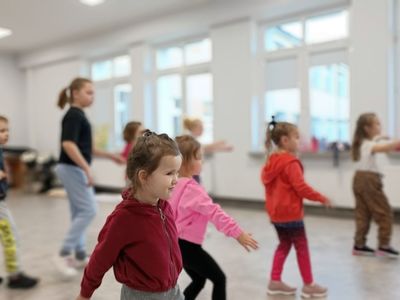 Dzieci z grupy początkującej z trenerem wykonują określone ćwiczenia. 
