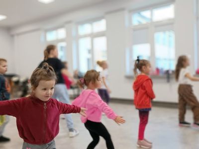 Dzieci z grupy początkującej z trenerem wykonują określone ćwiczenia. 
