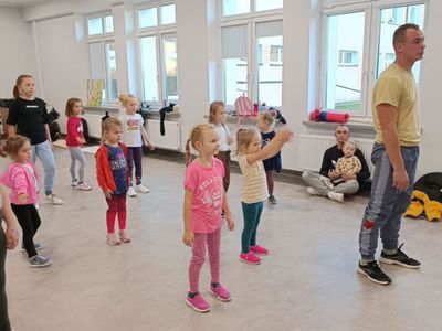 Dzieci z grupy początkującej z trenerem wykonują określone ćwiczenia.