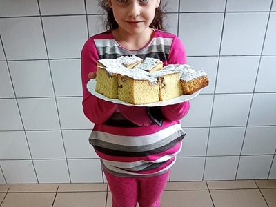Wychowanka z Placówki Wsparcia Dziennego w Laskach prezentuje upieczone ciasto z jabłkami.