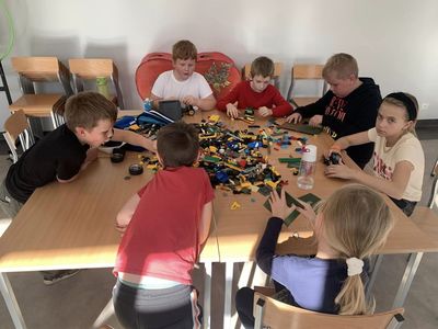 Dzieci ze Świetlicy Kultury w Malechowie układają pojazdy z klocków lego.