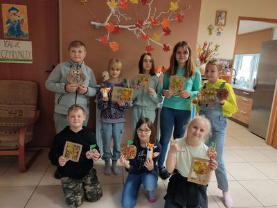 Dzieci z Kosierzewa pozują z kartkami, papierowymi ozdobami nawiązującymi do jesieni. 