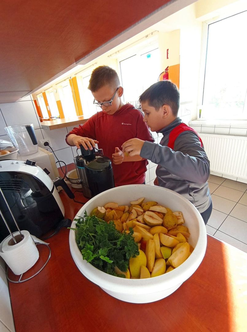 Dwaj chłopcy przygotowują sok z gruszek.