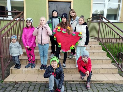 Dzieci z Kosierzewa pozują przed świetlicą z przygotowanym plakatem. 