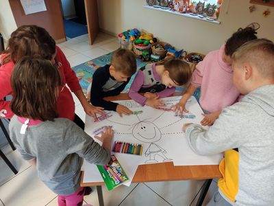 Dzieci z Placówki Wsparcia Dziennego w Kosierzewie przygotowują plakat na temat oszczędzania. 
