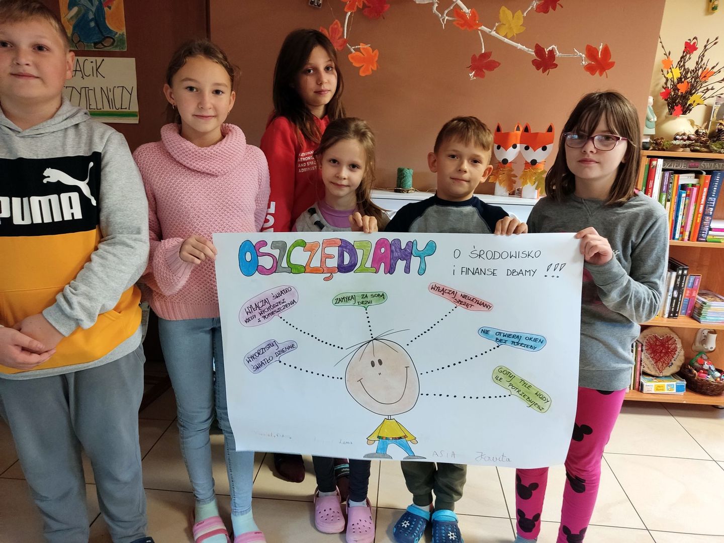 Dzieci z Placówki Wsparcia Dziennego w Kosierzewie prezentują wykonany plakat na temat oszczędzania.