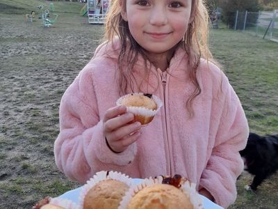 Dziewczynka z Placówki Wsparcia Dziennego w Sulechowie pozuje z przygotowanymi babeczkami. 