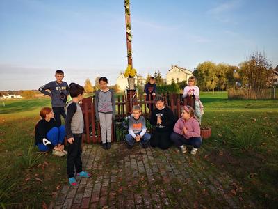 Wychowankek Placówki Wsparcia Dziennego w Kusicach podczas zapalania zniczy przy krzyżu w miejscowości Kusice. 