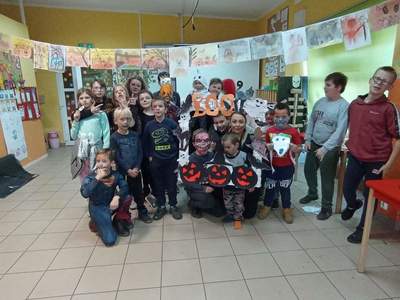 Dzieci z Placówki Wsparcia Dziennego z Lasek wraz z wychowawcą prezentują stroje na Halloween.