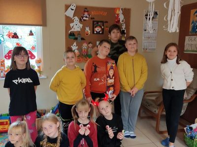 Grupa wychowanków z Placówki Wsparcia Dziennego w Kosierzewie. w tle dekoracja na Halloween.
