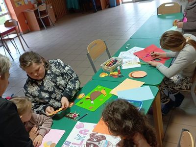 Dzieci z PWD z Lasek wykonują pieski z kolorowych kółek.