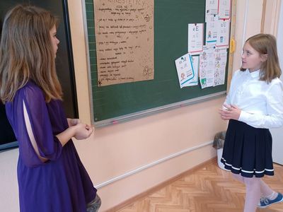Uczennice prezentują plakat "Jak uczą się kinestetycy?"