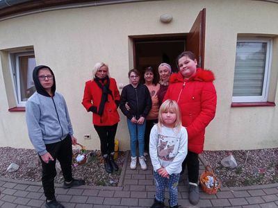 Wychowankowie z PWD z Lasek wręczają seniorce drzewko szczęścia.