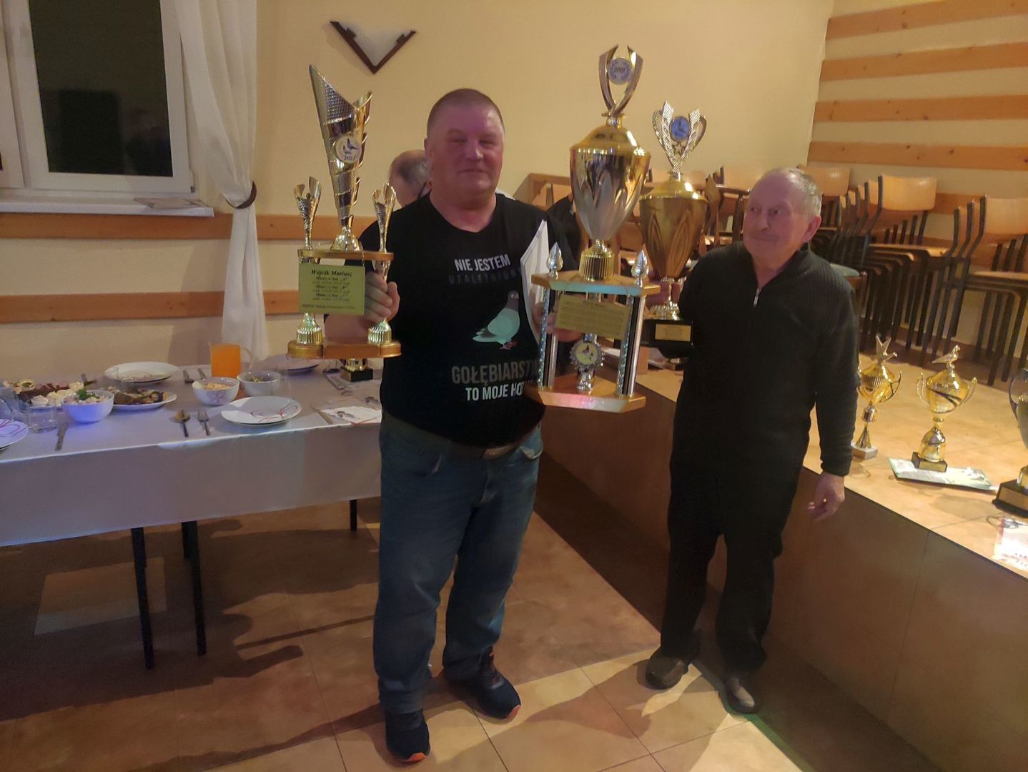 Nagrodzony hodowca prezentuje zdobyte trofea. Obok przedstawiciel sekcji, który wręczył nagrody.