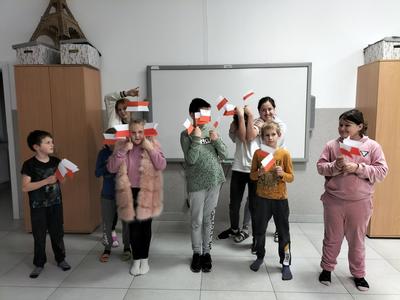 Dzień Niepodległości u dzieci z Placówki Wsparcia Dziennego w Kusicach, które pozują z flagami.