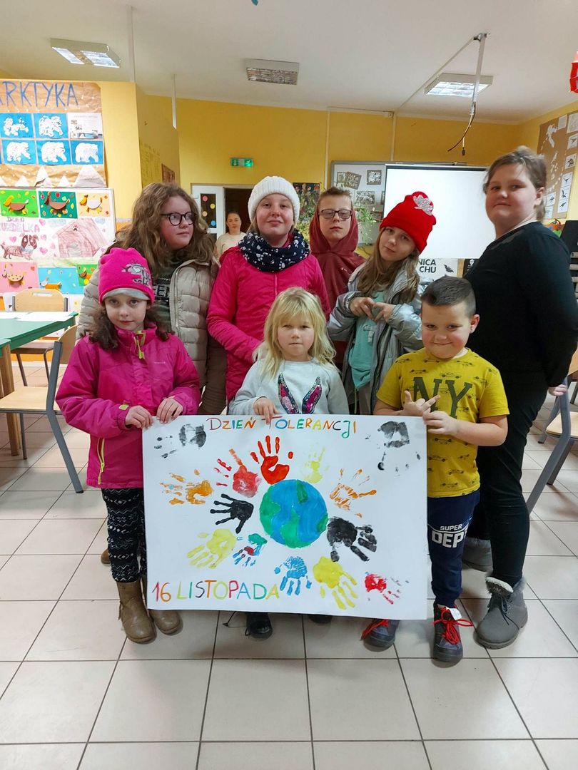 Wychowankowie z Placówki Wsparcia Dziennego z Lasek prezentują wykonany plakat.  
