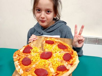 Ola z Placówki Wsparcia Dziennego w Niemicy prezentuje swoją pizzę.
